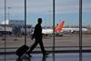 Silhouette of a traveller at an airport with aeroplanes in the background