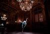 Ballet dancer performing beneath a chandelier.
