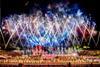 Firework display above crowd of performers