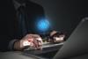 Man at laptop using AI chatbot to organise travel plans