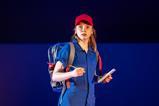 Young woman wearing red hat, blue boiler suit and holding note pad and pen