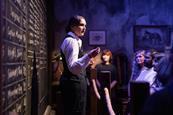 An actor with guests at the Peaky Blinders Underworld experience