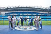 A group who are pitchside at the Etihad Stadium tour in Manchester