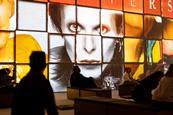 People sat in front of a screen depicting David Bowie's face