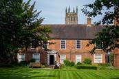 Old red brick building with large gardens