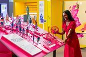 A woman looks at the We Go Way Back exhibition, touching different objects