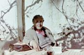 Agatha Christie sat at a table beneath a tree