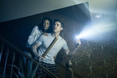 Couple going down stairs with torch and baseball bat