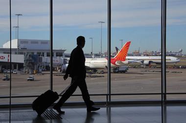 Silhouette of a traveller at an airport with aeroplanes in the background