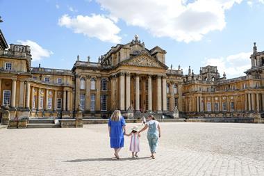 Two women and a young girl walk outside Blenheim Palace in Oxfordshire