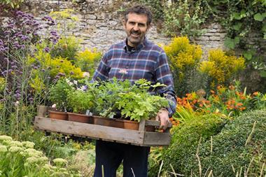 Gardeners' World presenter Adam Frost in a garden.