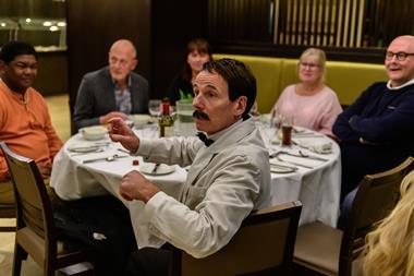 Manuel with diners at the Faulty Towers The Dining Experience in London