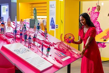 A woman looks at the We Go Way Back exhibition, touching different objects