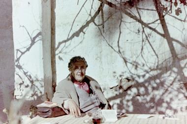 Agatha Christie sat at a table beneath a tree