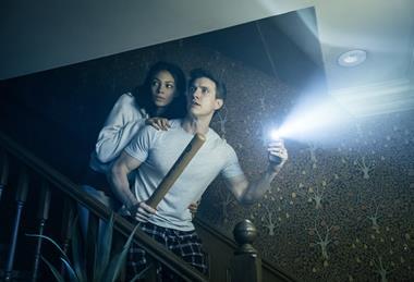 Couple going down stairs with torch and baseball bat
