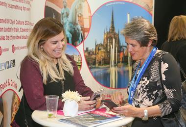 Exhibitors talk to visitors at the Group Leisure & Travel Show
