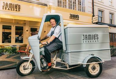 Jamie Oliver driving a scooter outside Jamie's Italian restaurant in the West End