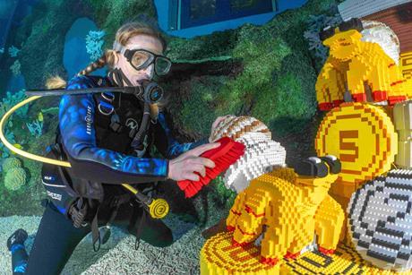 Diver cleaning LEGO model underwater