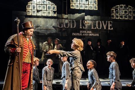 Oliver asks Mr Bumble for more gruel in the West End production of Oliver!