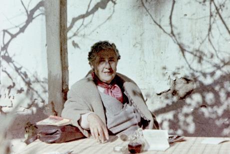 Agatha Christie sat at a table beneath a tree