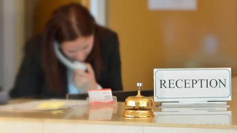 A receptionist on the phone at a hotel desk