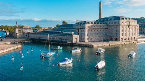 Boats and paddle boarders in the water next to the Royal William Yard in Portsmouth