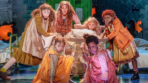 Zoe Akinyosade (Annie) and Company on stage in the Annie musical tour 2023.