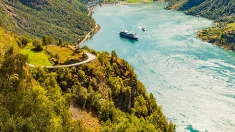 A cruise boat navigates the stunning fjords in Norway
