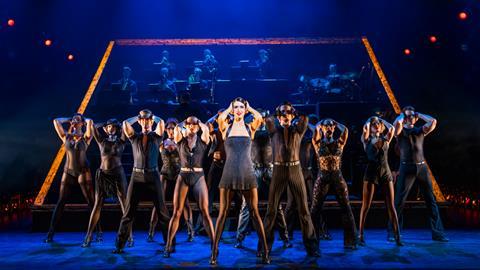 The cast of Chicago perform on stage backed by the live band