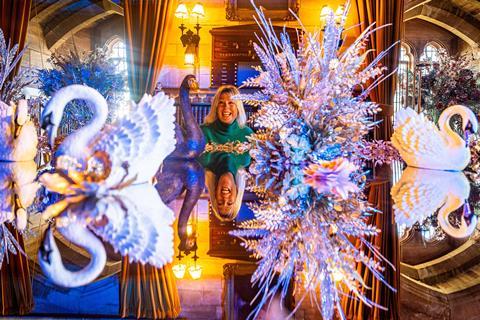 A lady looking at decorated swans as part of Bamburgh Castle's Christmas theme