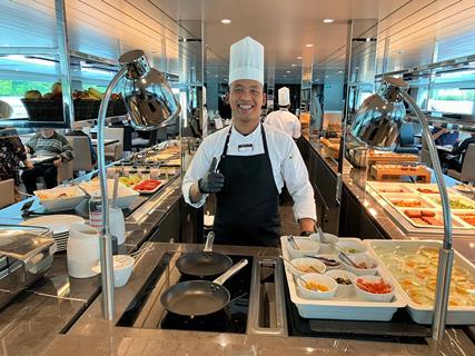 A chef serves food on board Scenic Amber river cruise ship.