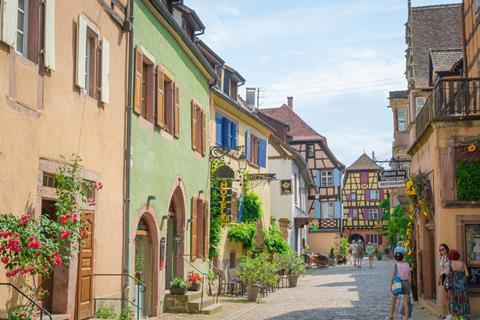 Pastel coloured houses on a cobbled street in Alsace