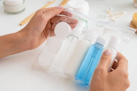 Hands using clear vanity liquid toiletries case for airport security