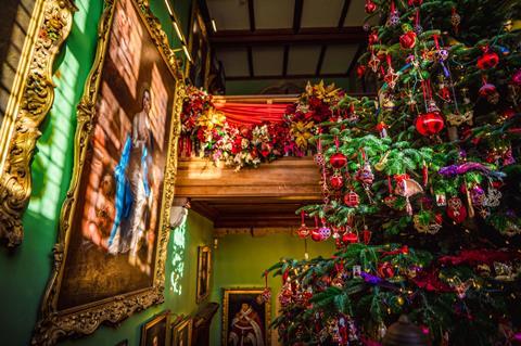 An elaborately decorated Christmas tree opposite portraits