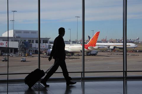 Silhouette of a traveller at an airport with aeroplanes in the background