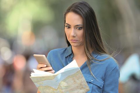 Tourist using mobile abroad with map