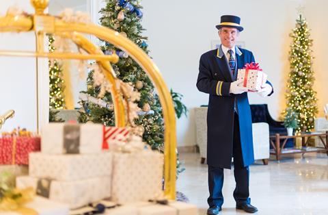 A doorman holds a gift for guests arriving at one of the Brend Collection hotels for a Christmas break.