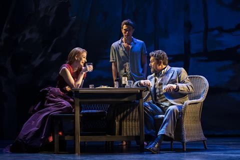 The cast of Aspects of Love sat at a table on the stage at London's Lyric Theatre.