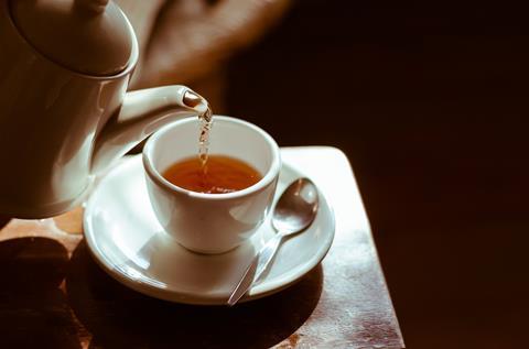 Tea being poured into a cup and saucer