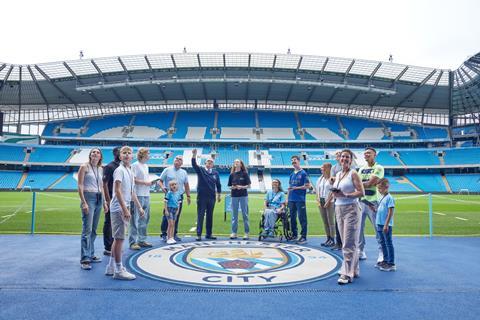 A group who are pitchside at the Etihad Stadium tour in Manchester