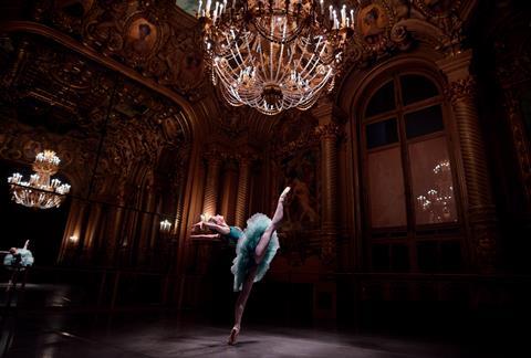 Ballet dancer performing beneath a chandelier. 