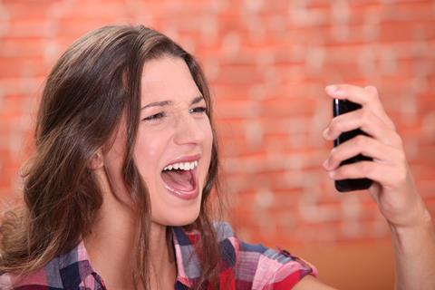 Woman shouting into her mobile phone on loud speaker