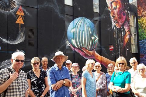 Members of the Tunbridge Wells U3A outside a street mural in Shoreditch, London