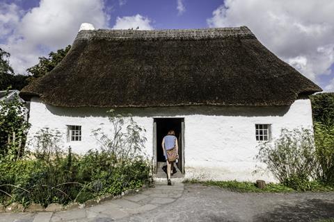 Woman walking into a building at St Fagans National Museum of History