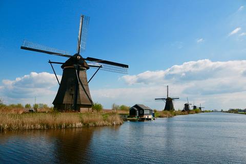 Traditional Dutch windmills beside a wide river