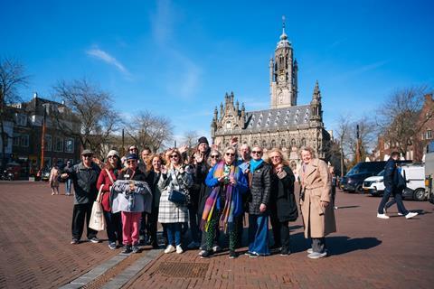 A group of people poses in front of a church in a European city