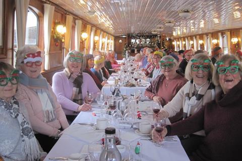 Group members wear their festive glasses on board The Georgian boat in Windsor for a Christmas lunch and cruise