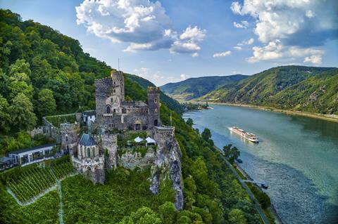 A cruise ship passing a castle on the Rhine river