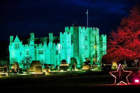 Hever Castle at night with vibrant Christmas lights projected