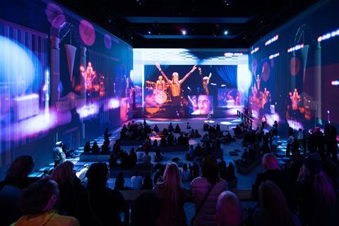 Audience watches David Bowie performance on large screens around room